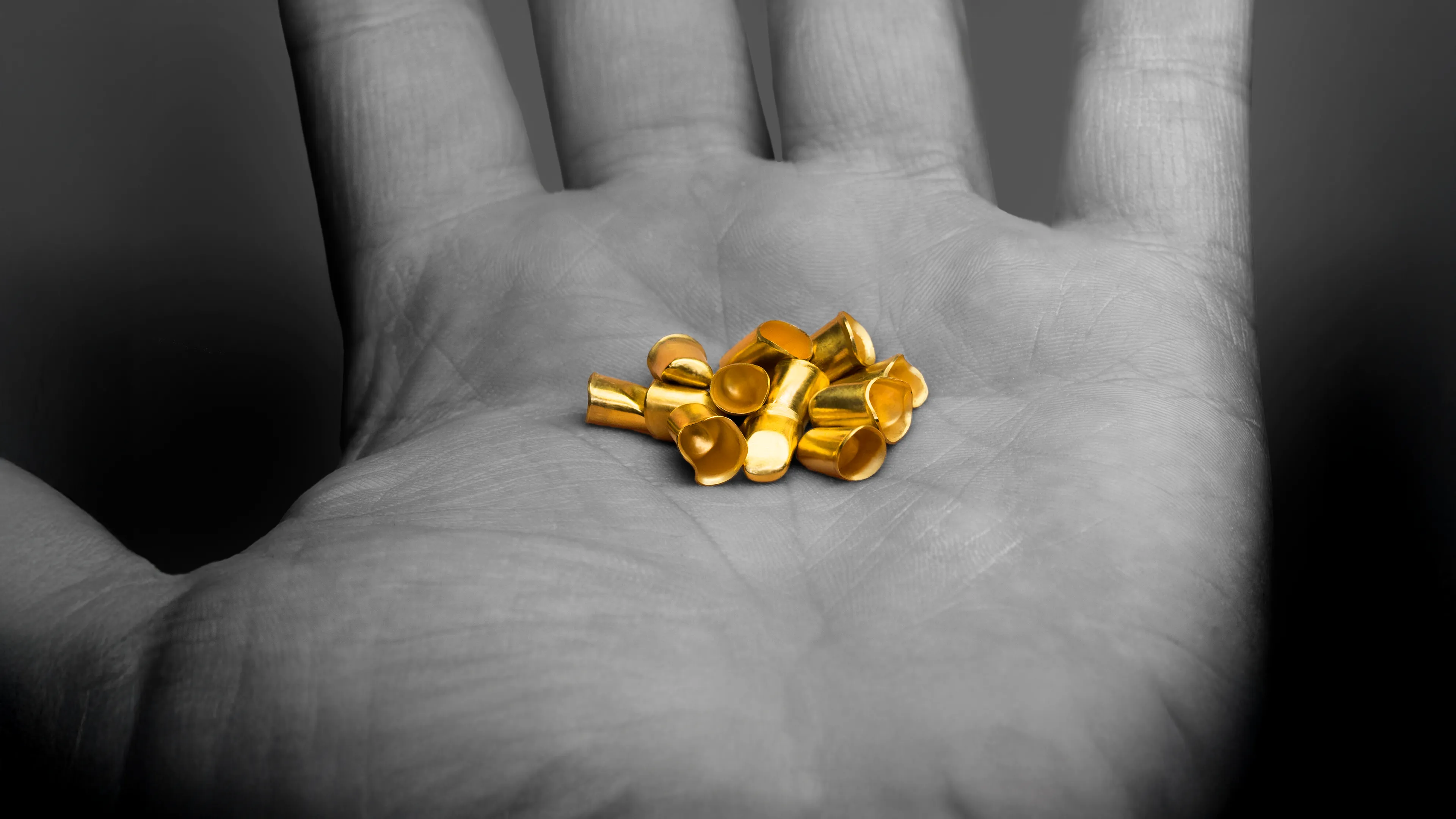 Goldene Galvanokappen auf einer Handfläche